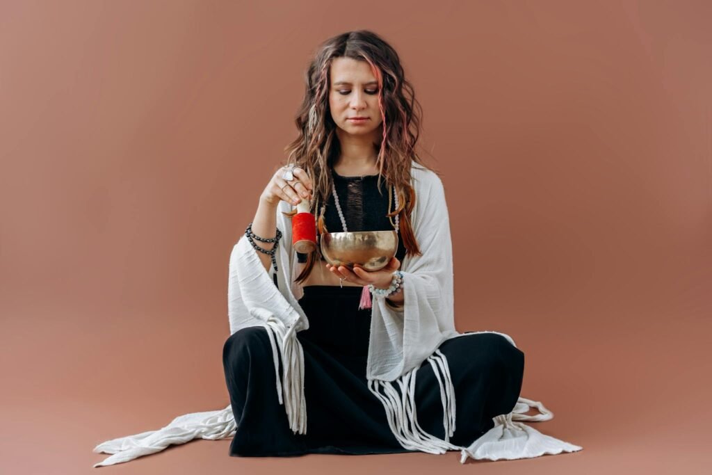 A serene woman meditates with a singing bowl, evoking a sense of peace and balance.